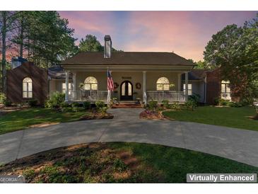 Charming home with a circular driveway and welcoming front porch perfect for relaxing and entertaining at 3806 Bill Gardner Pkwy, Locust Grove, GA 30248