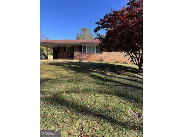 Brick ranch house with a spacious lawn and mature trees at 1310 Celia Way, Decatur, GA 30032