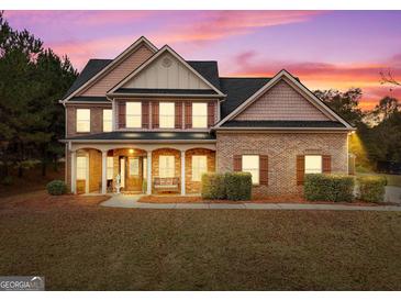 Brick two-story house with a covered porch and landscaped yard at 101 Elite Way, Mcdonough, GA 30252