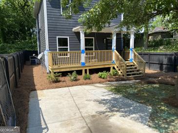 Newly constructed home with a deck, fresh landscaping, and a paved driveway at 935 Pelham Nw St, Atlanta, GA 30318