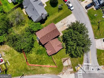 Aerial view of a home with mature trees, a fenced yard, and a convenient location on a quiet street at 5260 Shirewick Dr, Lithonia, GA 30058