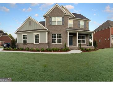 Two-story brick home with gray siding and landscaped lawn at 7019 Blue Sky Dr, Locust Grove, GA 30248