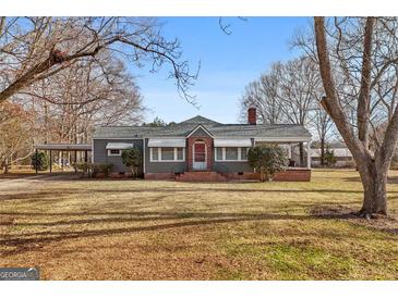 Gray house with brick accents, covered porch, and large yard at 60 N East Main St, Hampton, GA 30228