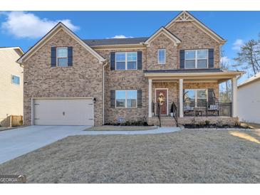 Two story house with brick facade, three car garage, and landscaped lawn at 5626 Wyncreek Sw Cir, South Fulton, GA 30331