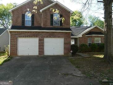 Brick two-story house with a three-car garage and a well-maintained lawn at 4408 Idlewood Park, Lithonia, GA 30038