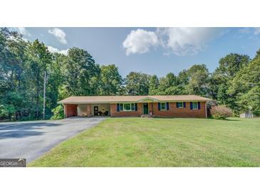 Charming brick ranch home featuring a carport, manicured lawn, and classic shutters at 677 Gum Creek Rd, Oxford, GA 30054