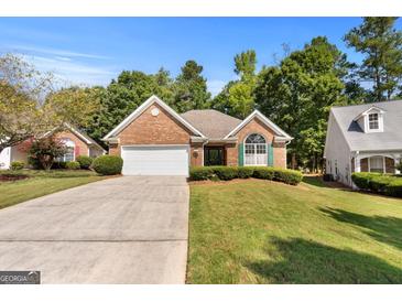 Brick ranch home with attached garage and landscaped lawn at 1152 Strath Clyde Way, Mcdonough, GA 30253