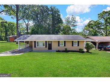 Ranch style home with a covered porch and well-maintained lawn at 3226 Browns Mill Se Rd, Atlanta, GA 30354