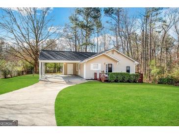Ranch home with carport, deck, and landscaped yard at 220 Mountain View Cir, Covington, GA 30016