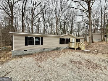 Charming single-story home with black shutters and a wooden porch in a wooded lot at 48 Pinewood Dr, Carrollton, GA 30116