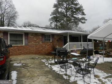 Brick ranch home with a covered porch, patio, and spacious yard at 1434 Butler St, Jonesboro, GA 30236