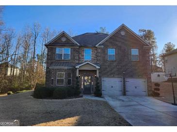 Two-story brick home with a three-car garage and landscaped yard at 116 Telfair Ln, Mcdonough, GA 30253