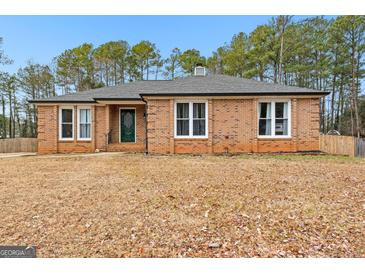 Brick ranch house with a green door and mature trees at 206 Sandown Drive, Peachtree City, GA 30269