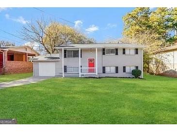 Ranch style home with gray exterior, red door, and spacious lawn at 2959 Fairburn Rd, Atlanta, GA 30331