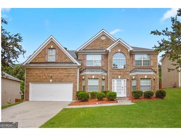 Traditional brick home with well-manicured front lawn and mature landscaping at 319 Allegrini Dr, Atlanta, GA 30349