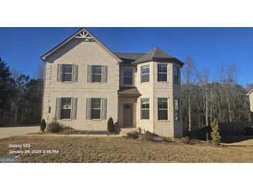 Two-story home with brick and gray siding, and landscaping at 352 Traditions Ln, Hampton, GA 30228