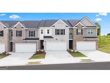 Three-story townhouses with attached garages and landscaping at 300 Silver Moon Drive, Loganville, GA 30052