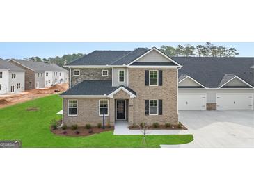 Two-story brick home with gray accents and a landscaped lawn at 596 Silver Moon Drive, Loganville, GA 30052