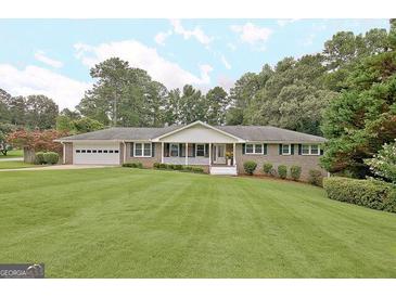 Ranch house with a large front yard and attached garage at 100 Aspen Way, Fayetteville, GA 30214