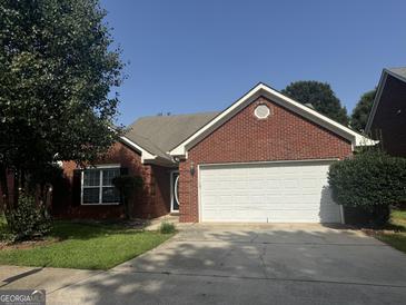 Brick house with a two-car garage and well-maintained lawn at 235 Long Dr, Mcdonough, GA 30253