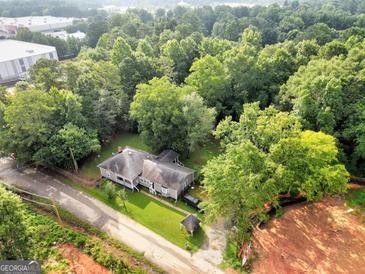 Aerial view of a house with a large backyard and surrounding trees at 4995 Reservoir Dr, Douglasville, GA 30135