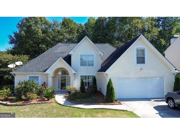 Two-story house with a large front yard, attached garage, and landscaping at 200 Kensington Trce, Stockbridge, GA 30281