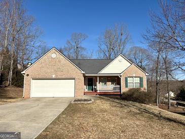 Brick ranch house with attached garage and landscaped yard at 504 Plantation Creek Dr, Loganville, GA 30052