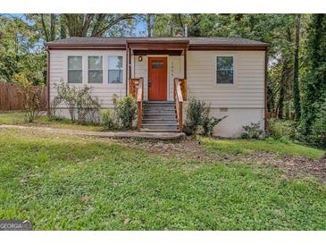 Updated Ranch home with orange front door and landscaped lawn at 1256 Elizabeth Sw Ave, Atlanta, GA 30310