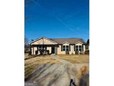 Charming single-story home featuring a well-manicured lawn and classic suburban appeal at 415 Dove Ln, Social Circle, GA 30025