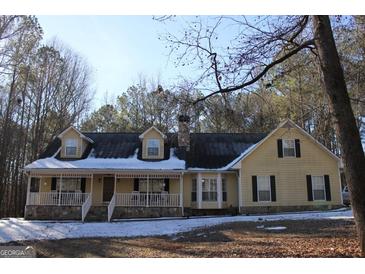 Two-story house with a wraparound porch and stone accents at 155 Carriage Gate Dr, Sharpsburg, GA 30277