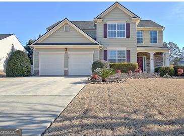 Two-story house with a large yard, two-car garage, and landscaping at 704 Pine Grove Cir, Peachtree City, GA 30269