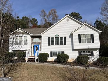 Two-story house with white siding, blue door, and landscaping at 135 Tuscany Trce, Dallas, GA 30157