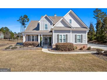 Charming gray home featuring beautiful landscaping, a welcoming porch, and classic architectural details at 244 Sturry Dr, Mcdonough, GA 30252