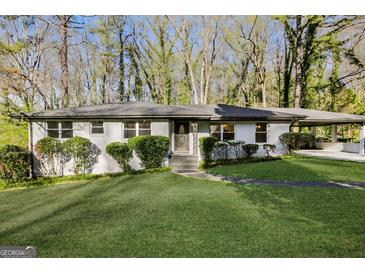 Ranch style home with white brick exterior, landscaped lawn, and carport at 1544 Austin Rd, Atlanta, GA 30331