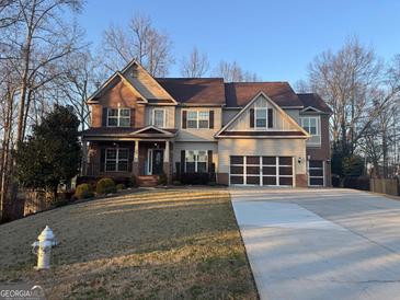 Two-story house with brick and siding, large driveway and landscaped yard at 329 Shyre Lake Ln, Mcdonough, GA 30253