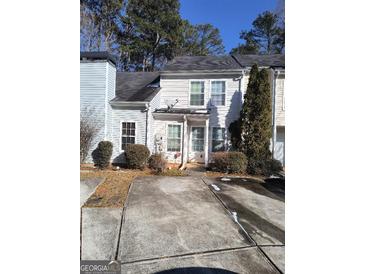 Two-story townhouse with a concrete driveway and small front yard at 2590 Wellington Walk Pl, Lithonia, GA 30058