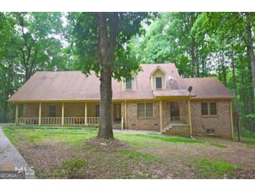 Brick ranch home with covered porch and large yard at 6051 Reynolds Rd, Morrow, GA 30260