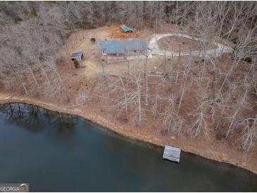 Secluded lakefront property featuring a charming home, private dock, and tranquil surroundings, perfect for peaceful living at 3505 Gum Creek Rd, Oxford, GA 30054
