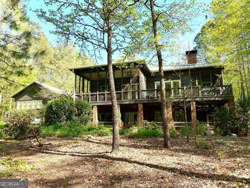 Two story house with large deck and screened porch, nestled in a wooded area at 500 Augusta Ln, Chattahoochee Hills, GA 30268