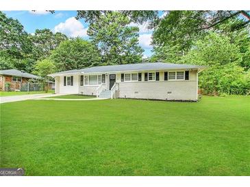 Ranch style home with a large front yard and mature trees at 4785 Kent Rd, Atlanta, GA 30337