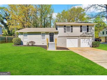 Gray brick ranch house with 2-car garage and landscaped lawn at 2318 Emerald Falls Dr, Decatur, GA 30035