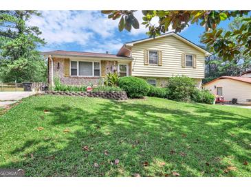 Two-story house with brick and siding, a sloping lawn, and a driveway at 214 W Windemere Way, Jonesboro, GA 30238