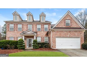 Brick two-story house with a large yard and a two-car garage at 5539 Halsey Trce, Atlanta, GA 30349