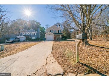 Charming two-story home featuring a well-maintained lawn and long driveway on a sunny day at 1129 Winston Dr, Decatur, GA 30032