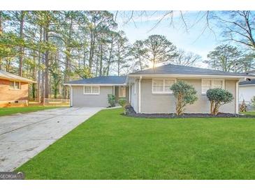 Ranch style home with gray exterior, landscaped lawn, and driveway at 1884 Derrill Dr, Decatur, GA 30032