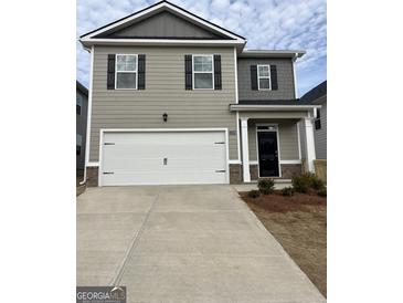 Charming two-story home featuring a two-car garage and a welcoming front porch at 12029 Conrad Circle, Hampton, GA 30228