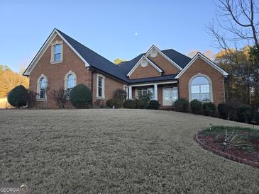 Brick home with a large front yard and a two-car garage at 55 Clearbrook Ct, Covington, GA 30016