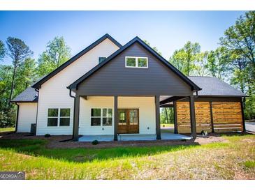 Beautiful modern farmhouse featuring a covered patio, open carport, and a light-filled, two-story design at 90 Ayers Rd, Bowdon, GA 30108