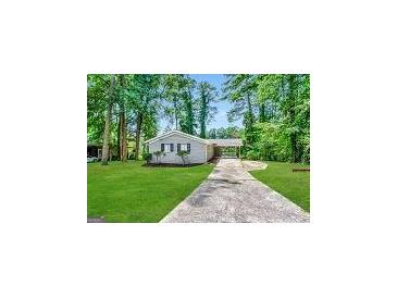 Ranch style home with a paved driveway and a well-maintained lawn at 2729 Pinella Sw Dr, Atlanta, GA 30331