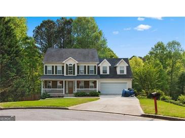 Two-story house with a large front porch and attached garage at 3065 Willow Park Dr, Dacula, GA 30019